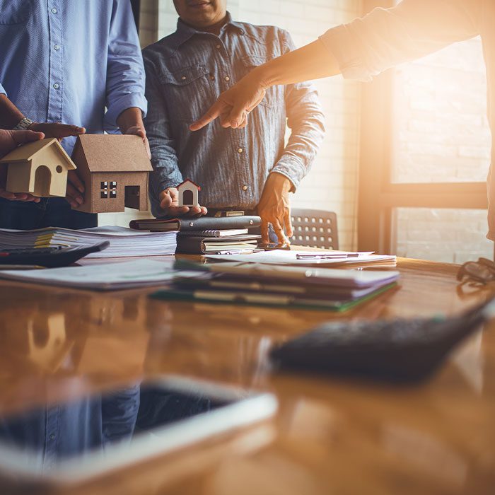 People gather around a table and discuss about properties