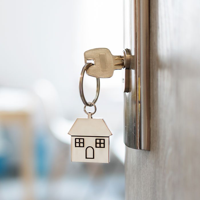 A key with house key chain on a door