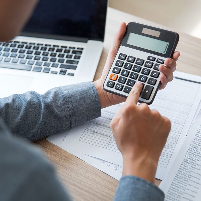 A person is using calculator to fill in the document