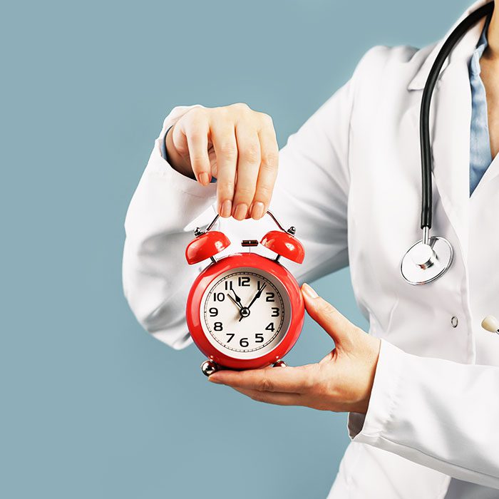 A doctor holds a clock