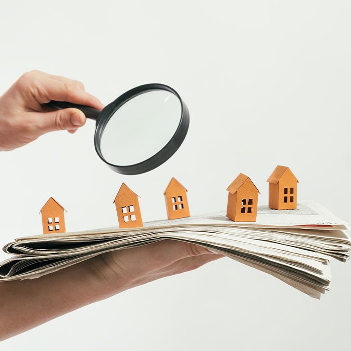 magnifying-glass-above-house-models