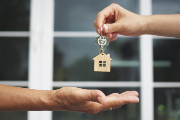 Property investor taking a home key from a seller or agent in front of a window