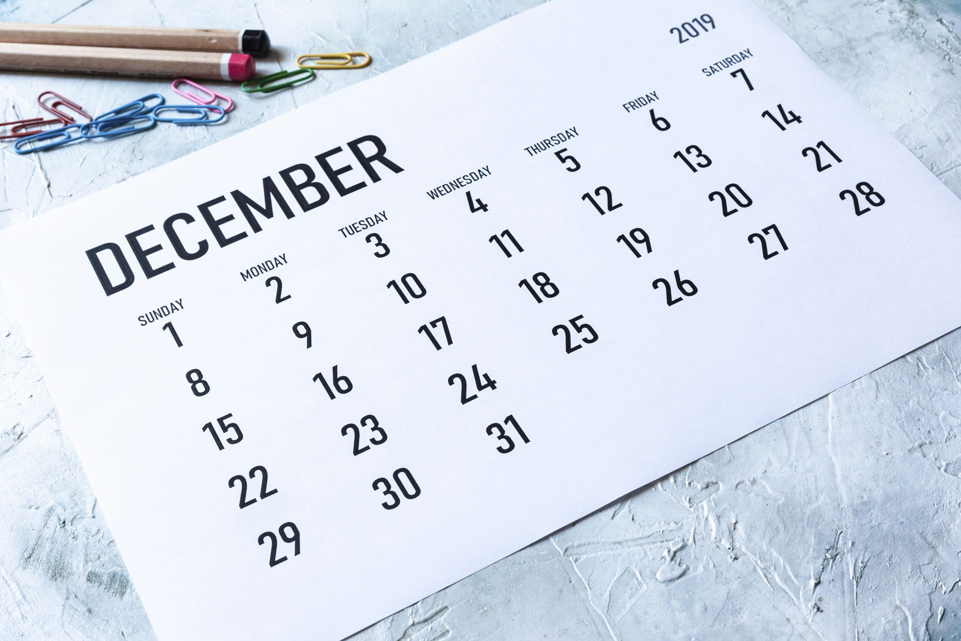 Simple 2019 December monthly calendar on table with office supplies