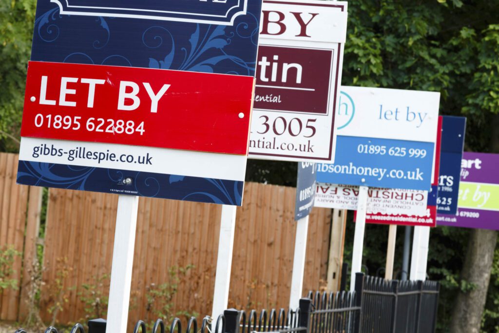 London, UK-circa 2013: Estate agent "let by" signs line the road in a suburb of London