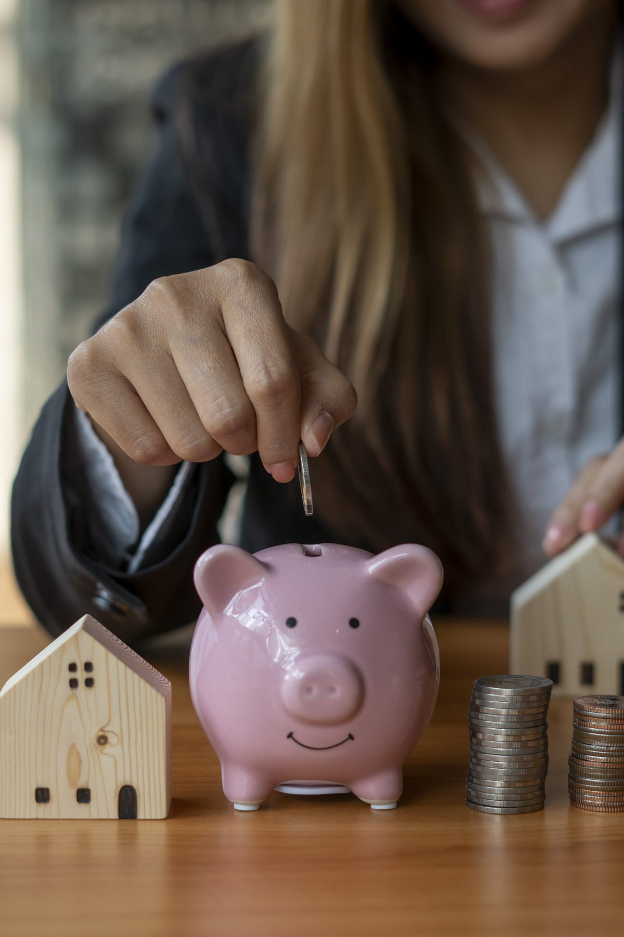 A woman's hand holds a coin to manage money and Plan your savings to buy the best home for your family, ideas for savings, growth, economy, business and investing.