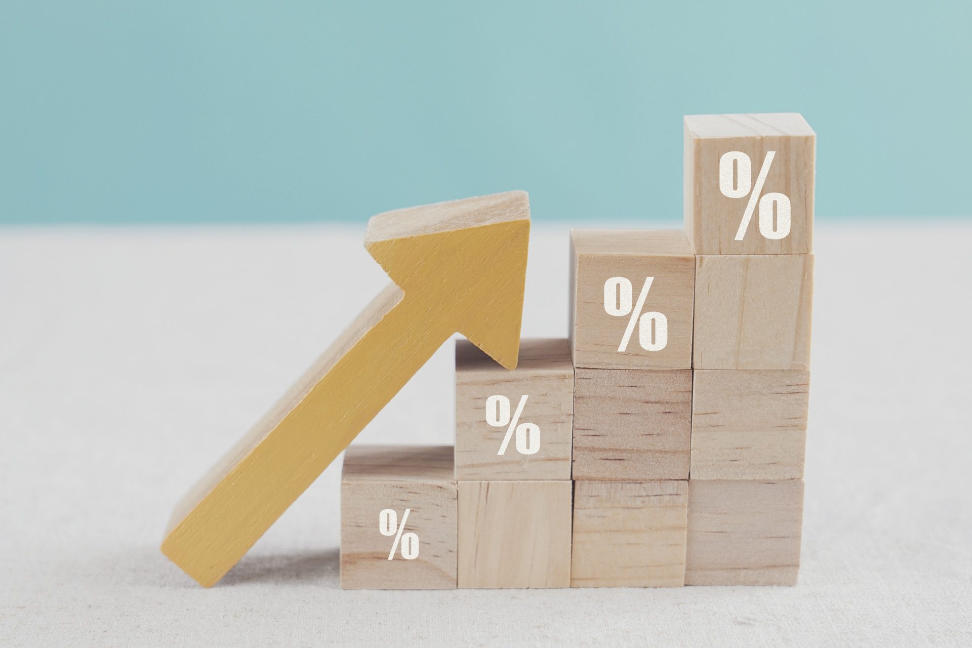 Wooden blocks with percentage sign and arrow up, financial growth, interest rate increase, inflation, high price and tax rise concept