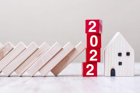 Red 2022 cube blocks stop falling blocks protect house miniature. fall Business, Home Insurance, investment, Crisis, Economic recession, New Year, Real Estate and Property concept