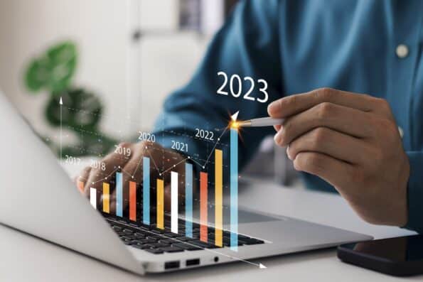 Businessman analyses profitability of property investment with digital augmented reality graphics showing growth in 2023