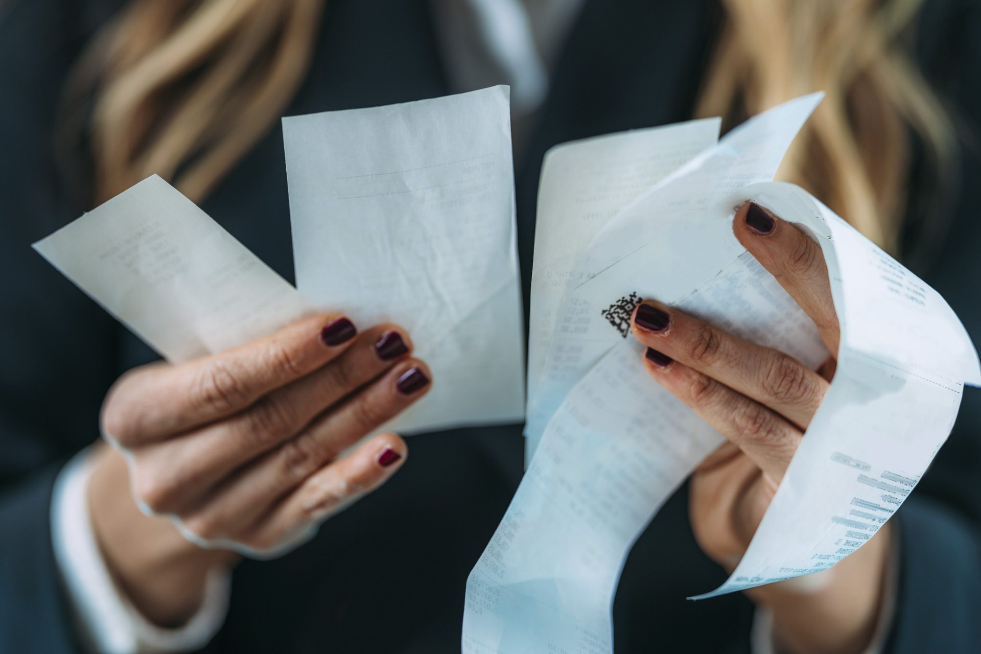 Inflation rising, costs increasing. Business woman holding Rising costs, declining standard of living, worried woman looking at increased costs on a printed receipt