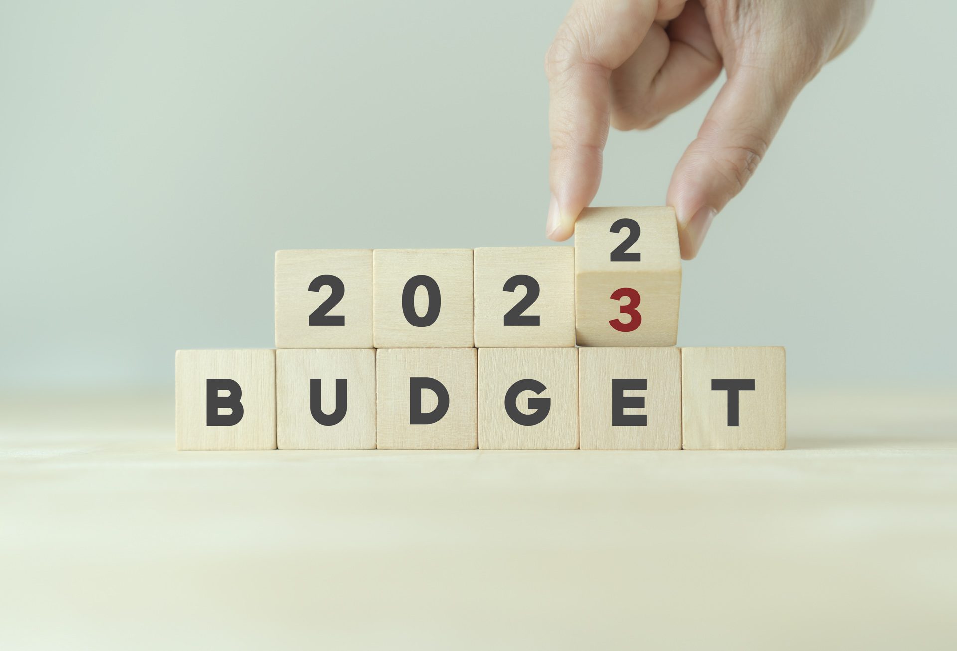 Hand flips wooden cube and changes the year from 2022 to 2023 representing the spring budget announcement