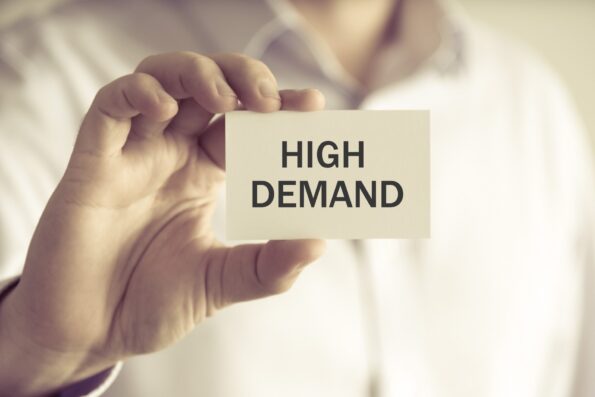 Property investor holding card saying 'high demand' to represent UK rental market