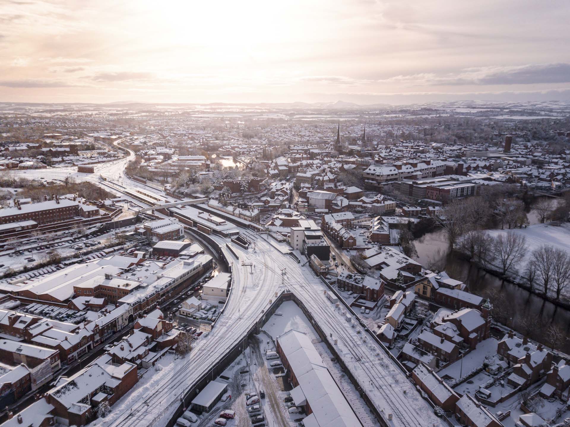 Aerial view of snow compromised rail and road networks. Snow, ice and winter weather conditions close railway links and shut roads causing transport delays and dangerous conditions.