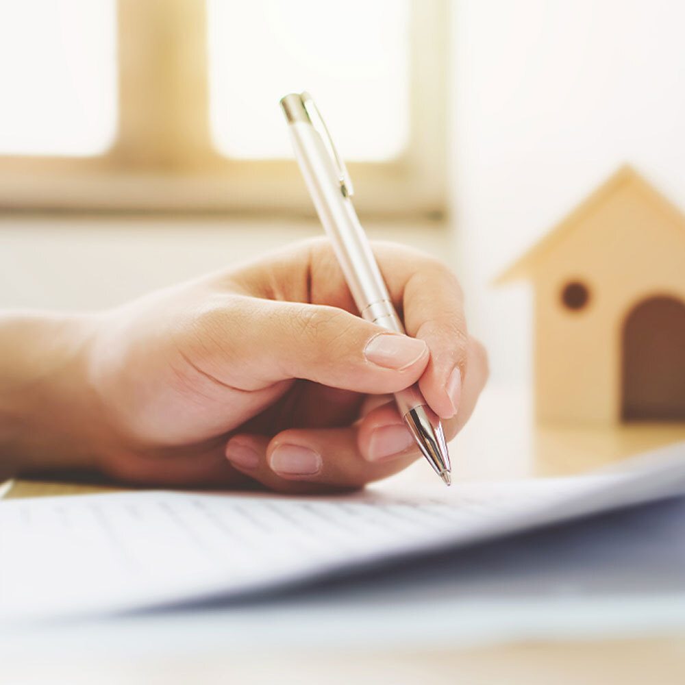 Hand signing a contract when buying a property