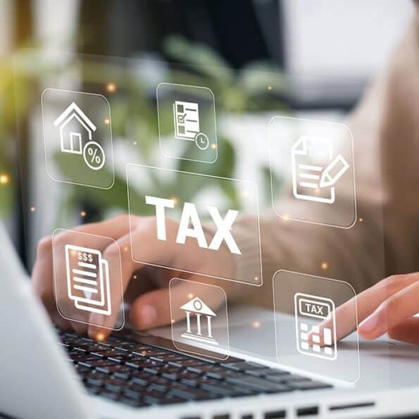 Person typing on a laptop with tax hologram