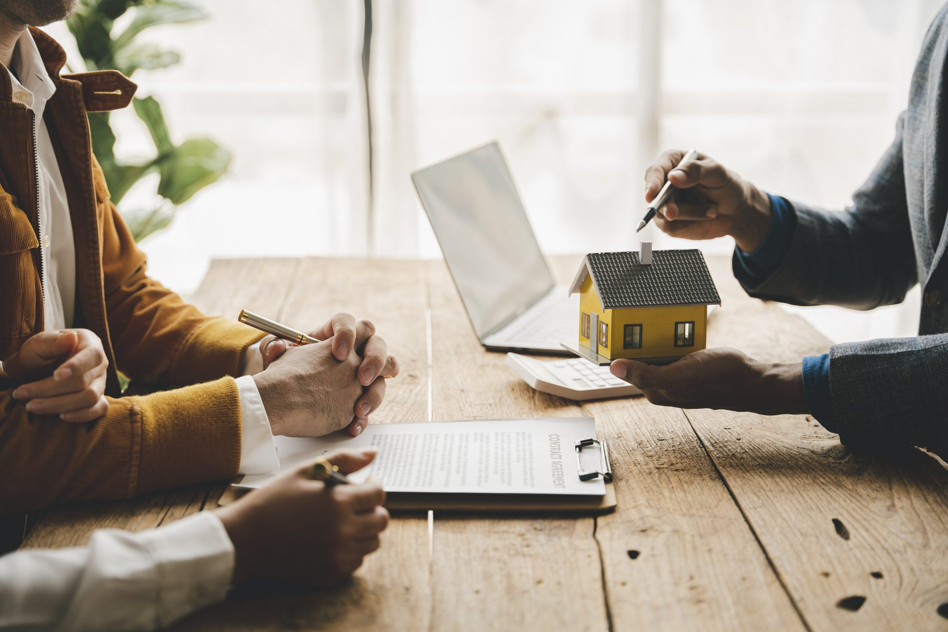 Property investors discussing a real estate opportunity with an agent about to sign a contract