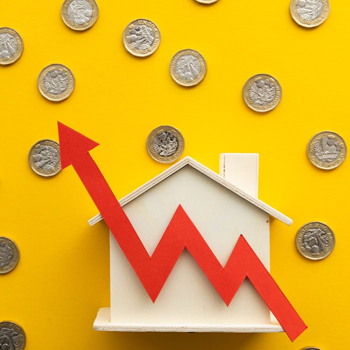 Arrow increase in front of a house model with coins in the background