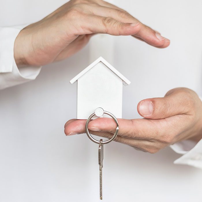 Two-hands-holding-house-model-and-key