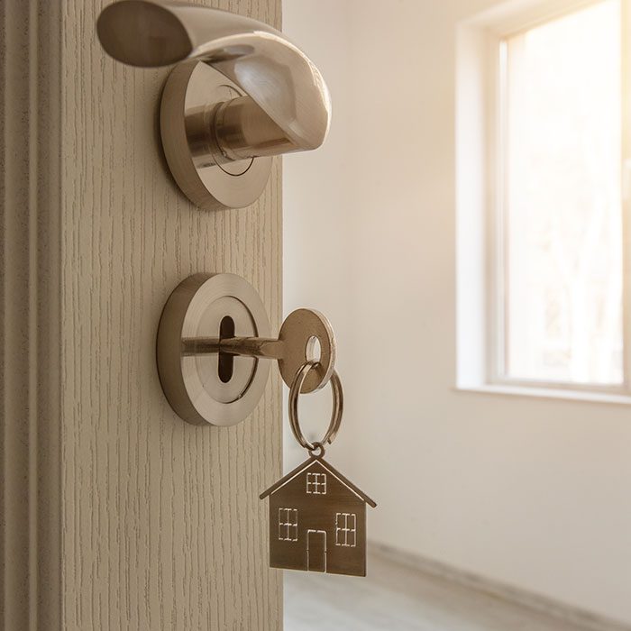 Key on a door with a house-shaped key chain