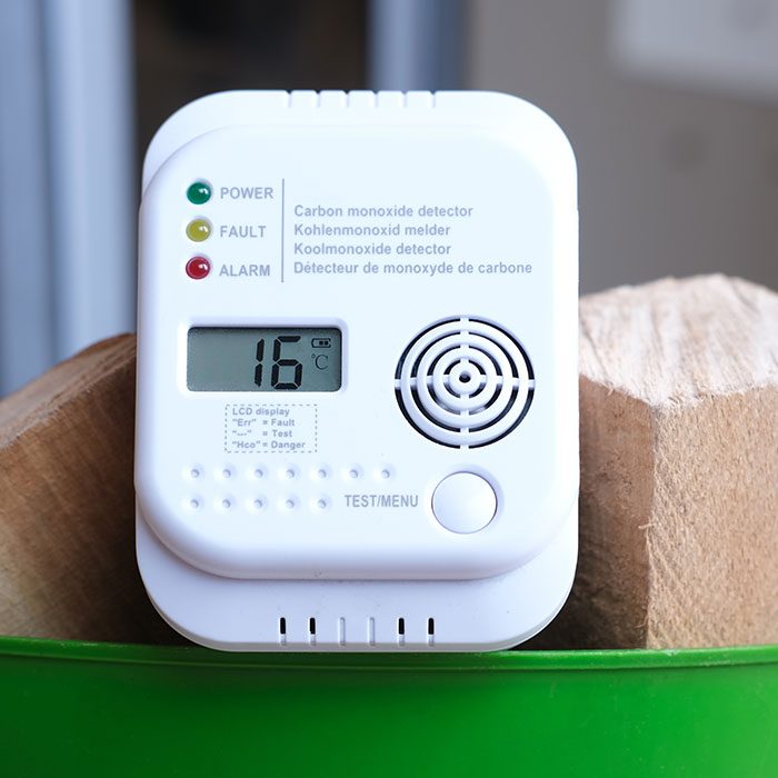 Carbon monoxide detector on a bucket of wood logs
