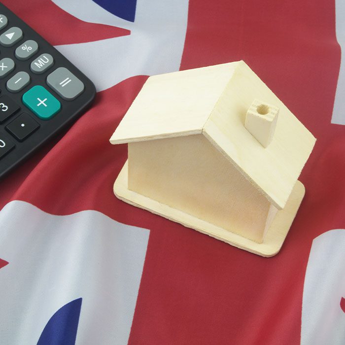 House model and calculator on a UK Flag