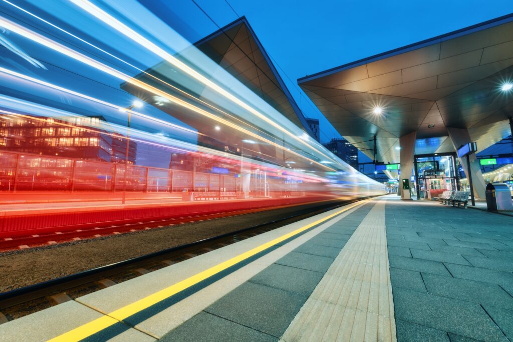 Image showing high-speed train moving quickly past platform