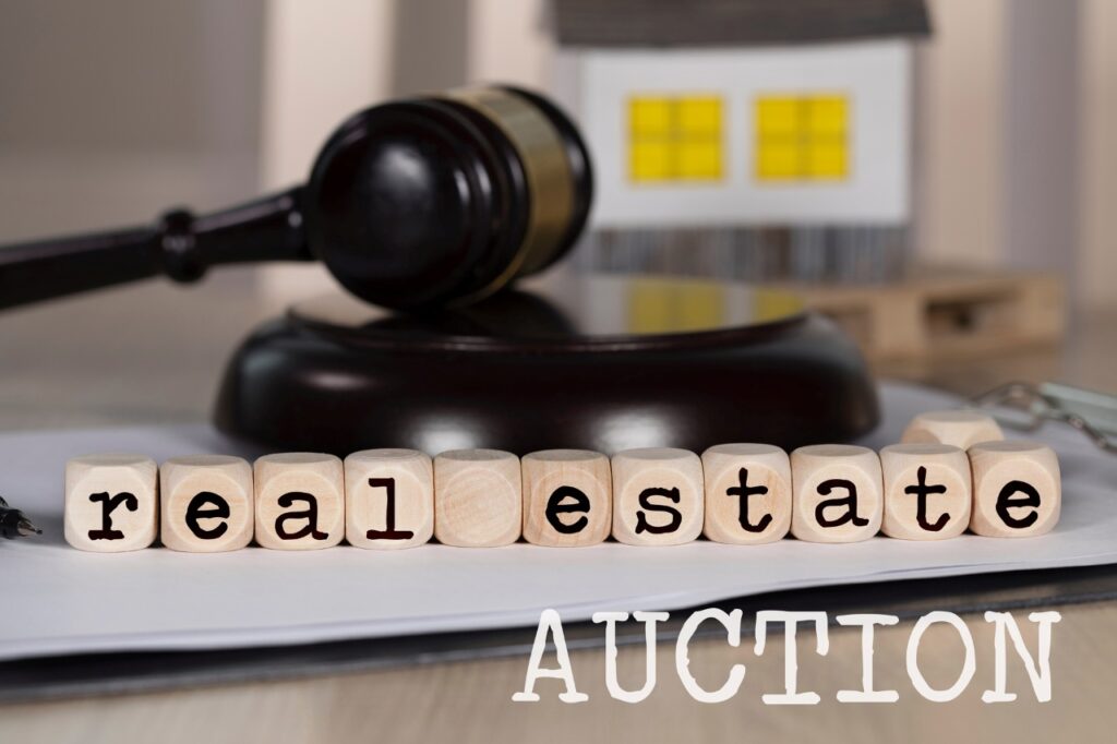 real estate spelled on wooden cubes with a gavel as background