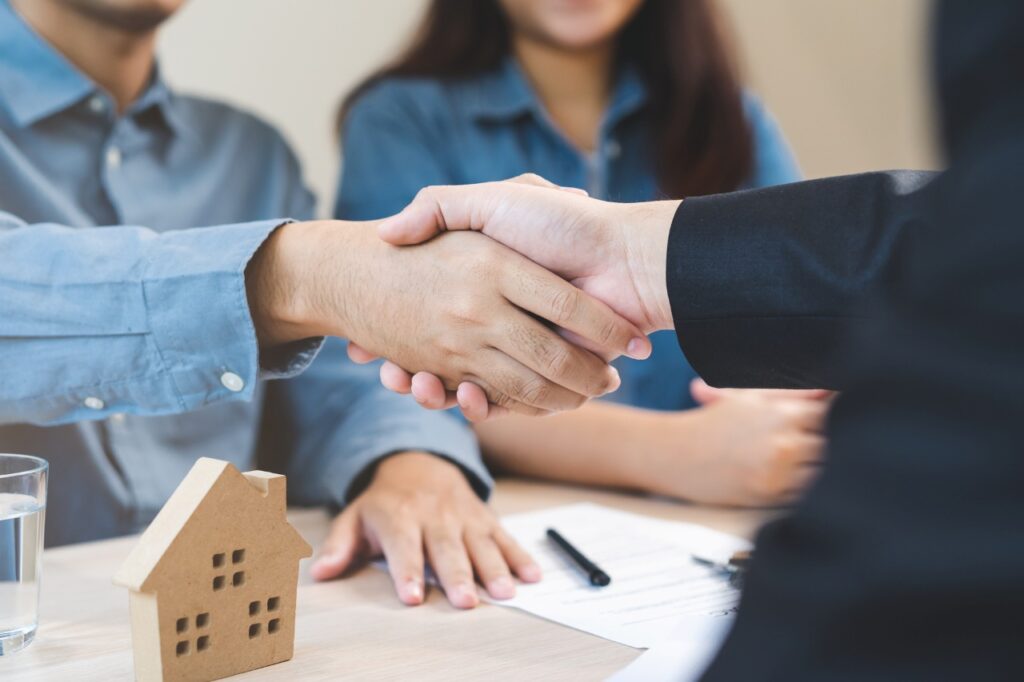 two person shaking hands over a real estate deal