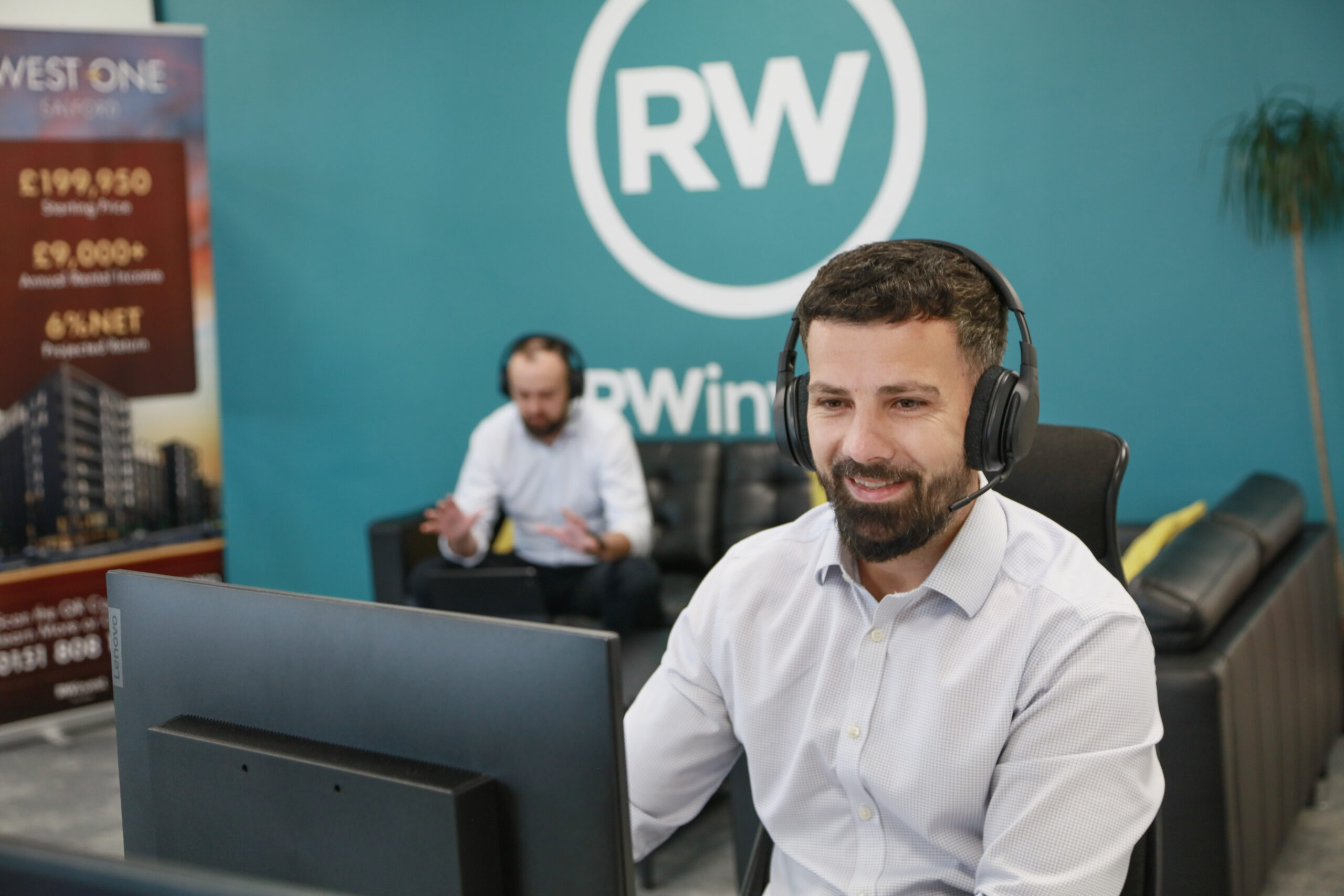 RWinvest office showing sales team working with logo in the background