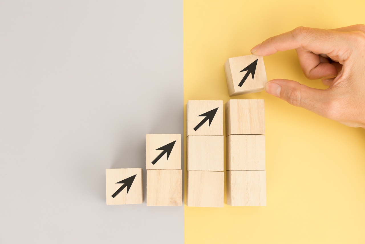 hand arranging wooden blocks with arrows pointing upwards