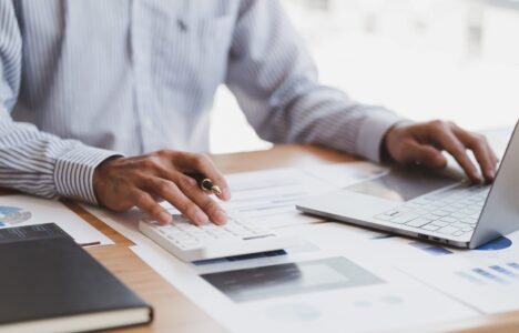 accountant working on calculator and laptop