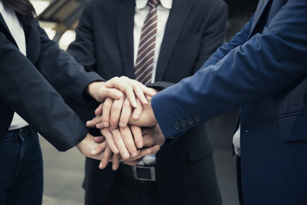 men in suit with their hands on top of each other's