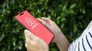 Arms of woman in striped top looking at Airbnb from a table device
