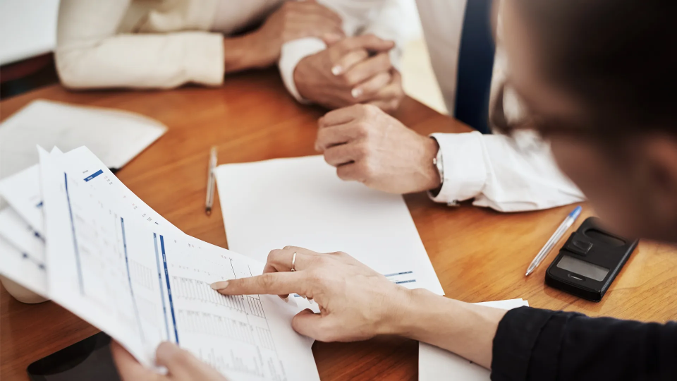 People at a table reviewing paperwork for business meeting