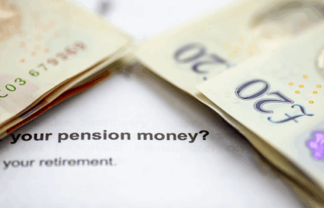 Money on top of paperwork displaying text about pension money